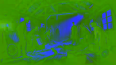 Inside an old shack with broken furniture, people gathered around, one pointing to a rat on the floor in a tense atmosphere.