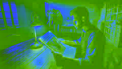 A man reads a newspaper clipping about an elephant and its keeper in a dimly lit room, absorbed in thought.