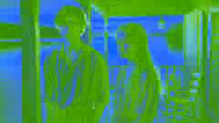 Harriet y Wyn en la terraza al atardecer, con un cielo dorado y un lago, evitando el contacto visual directo.