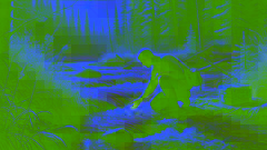 Un hombre se arrodilla al borde de un río de rápido cauce, sumergiendo su mano en el agua fría y clara.