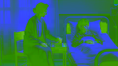 Mother sits beside her son’s hospital bed, placing a small gift box of candies on the nightstand