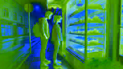 Una pareja está de pie frente a una panadería, mirando a través de la ventana los panes recién horneados.