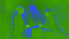 Holly conversa con la propietaria de la librería, Evelyn Hargrave, en una tienda oscura y sombría, rodeada de viejos libros y misterio.