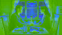 Jim und Della sitzen gemeinsam an ihrem Esstisch, Händchen haltend, von den Symbolen ihrer Opfer umgeben.
