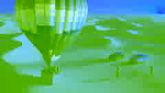 Puesta de sol con un globo aerostático a punto de aterrizar mientras un equipo de rescate los espera