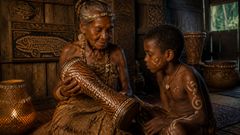À luz da chama da lâmpada e do cheiro de madeira úmida, os antigos entalhes despertaram uma casca de cada vez.