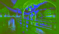 Ein Paar hängt ein Messingschloss an das Geländer der Liebesbrücke in Innsbruck, unter warmem Laternenlicht.